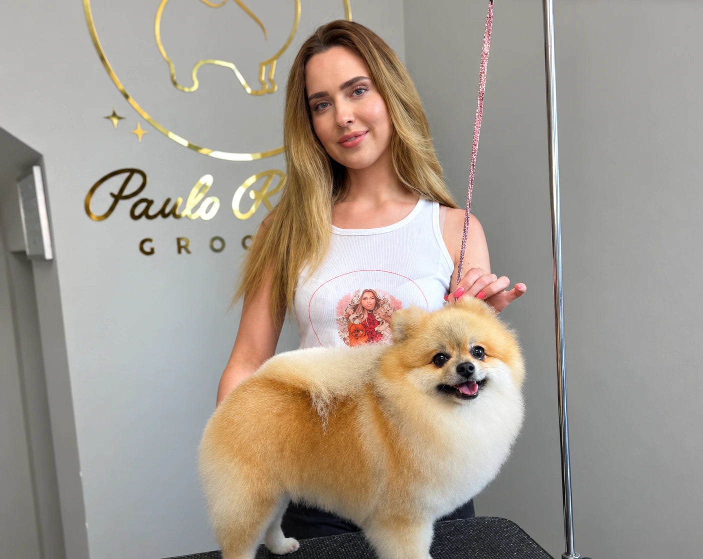 Romy holding a Pomeranian at The Groom Room salon